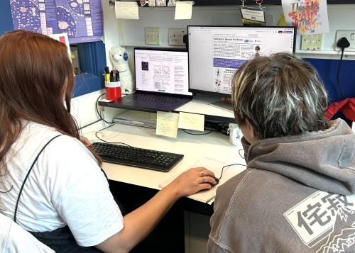 Chloe and Rose designing the newsletter at a computer